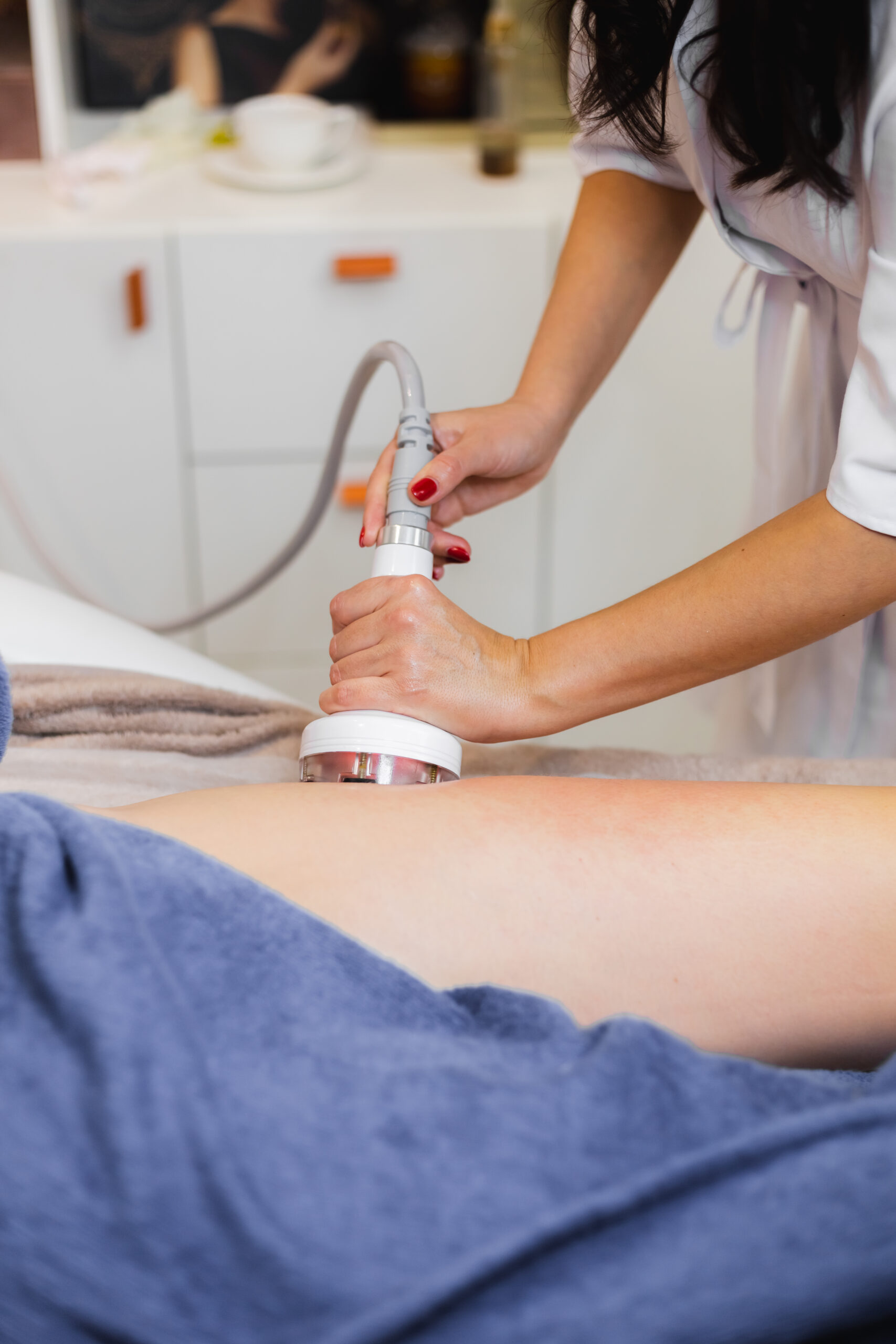 Masseur doing anti-cellulite massage to client in spa beauty salon using oil